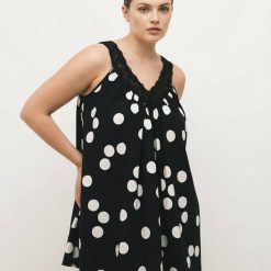 robes à pois grandes tailles monochrome dentelle babydoll v col courte popeline noire avec des pois blancs portée par une femme