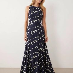robes a pois bleu marine longue godets dos nageur jupe sans manches coupe evasee fluide a motif imprime blanc portee par un mannequin