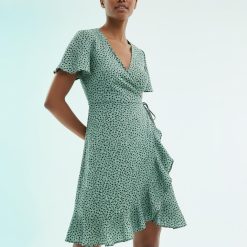 robes vertes à pois volants portefeuille courte vert portée par une jeune femme avec des manches courtes évasées et un col en v