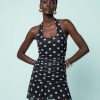 robes à pois noirs nu dos courte robe noir élégante sans manches avec des pois blancs fins et une coupe ajustée qui met en valeur la silhouette
