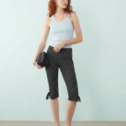 leggings à pois court blanc et noir monochrome0 porté par une femme avec un haut bleu et des mules noires