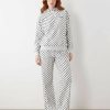 joggings à pois broderie ample logo pantalon ensemble gris et noir porté par une femme aux cheveux roux avec des baskets argentées