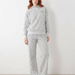 joggings à pois broderie ample logo pantalon ensemble gris et noir porté par une femme aux cheveux roux avec des baskets argentées
