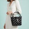 sacs de voyage à pois monochrome seau réglable avec bandoulière noir et blanc porté au bras par une femme habillée en blanc