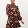 robes asymétriques à pois courte manches ballon col montant volants marron crème une robe élégante manches longues bouffantes à pois crème sur fond marron avec un col montant et des volants en bas de la jupe courtes
