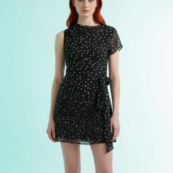 robes à pois noirs et blancs dos longue nu portée par une femme aux cheveux bouclés sur fond blanc