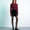 collants à pois noir femme style mode transparent chic portes par un mannequin avec une jupe noire et des mocassins