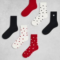 chaussettes à pois multicolore lot de 7 paires et cœurs disposées sur fond gris aux motifs de cœurs rouges noirs et blancs