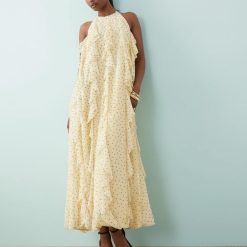 robes à pois jaune dos nu volants longue fleur anis élégante avec coupe fluide et motifs imprimés portée avec des sandales à talons noires