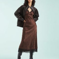 robes longues marron à pois rétro manches motif 29 robe nuisette longue en satin marron a pois noirs bordee de dentelle noire au col et a l ourlet portee avec une veste en cuir oversize et des bottes noires