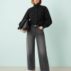 vestes à pois noir denim style cheminée col sport femme élégante portant une chemise noire à pois blancs et un jean ample gris foncé trouvés à la mode trouvés