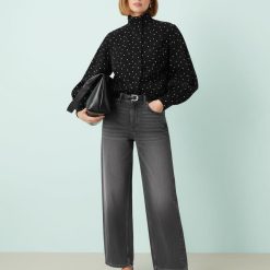 vestes à pois noir denim style cheminée col sport femme élégante portant une chemise noire à pois blancs et un jean ample gris foncé trouvés à la mode trouvés