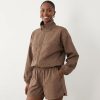 vestes à pois chocolat en cheminée nylon col ensemble avec veste zippée et short assorti imprimé pois marron porté par une femme