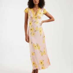 robes à pois jaune et rose longue imprimé coquelicots col v avec dentelle jaune aux manches et au décolleté portée par une mannequin avec des sandales blanches