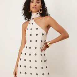 robes mousseline à pois crème avec col foulard courte asymétrique une épaule dénudée portée par un mannequin