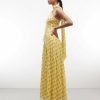 robes à pois jaune amovible détail foulard structurée taille longue style art déco portée par un mannequin de profil avec un col montant et un pan drapé dans le dos