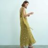 robes à pois jaune longue jacquard habillée dos ouvert portée par une femme de profil avec drapés fluides aux épaules