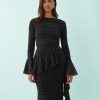 robes en tulle à pois volantés longue détails fronces noire à manches longues évasées portée par une mannequin sur fond bleu