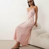 robes dentelles à pois roses en satin mi longue portée par une femme assise sur un meuble beige
