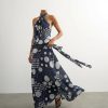 robes pin up à pois col halter taille basse longue noué bleu marine et blanc portée par un mannequin avec ceinture nouée sur le côté