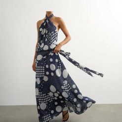 robes pin up à pois col halter taille basse longue noué bleu marine et blanc portée par un mannequin avec ceinture nouée sur le côté