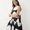 robes trapèze à pois boule courte coupe ourlet imprimé noir et blanc sans manches portée par une femme sur fond blanc