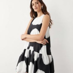 robes trapèze à pois boule courte coupe ourlet imprimé noir et blanc sans manches portée par une femme sur fond blanc