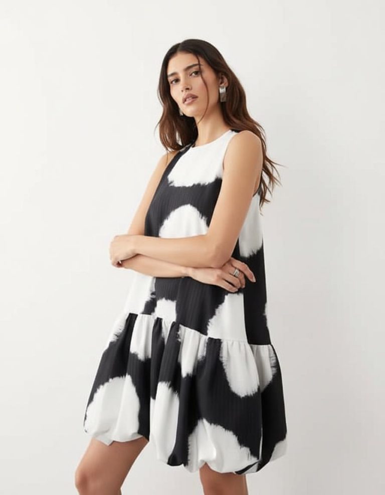 robes trapèze à pois boule courte coupe ourlet imprimé noir et blanc sans manches portée par une femme sur fond blanc