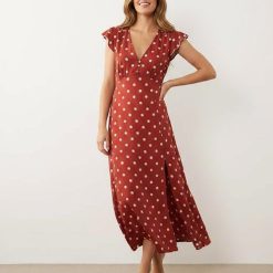 robes à pois rouge évasés col v et mancherons longue fluide portée par une femme avec une fente sur la jambe et boutonnière sur le décolleté