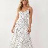 robes asymétriques à pois longue encolure dégagée beige ourlet midi femme élégante bretelles fines pois noirs fond blanc silhouette ajustée