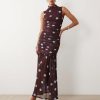 robes à pois rouge froncée basse taille encolure montante bordeaux sans manches imprimée de pois bleus portée par un mannequin