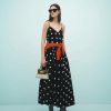 robes évasées à pois bouffante jupe coupée en biais trapèze mono longue robe noire a bretelles fines avec motifs a pois blancs et un pull orange noue a la taille