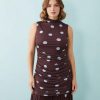 robes longues à pois rouge taille montante froncée encolure basse bordeaux sans manches portée par une mannequin sur fond bleu clair