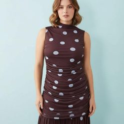 robes longues à pois rouge taille montante froncée encolure basse bordeaux sans manches portée par une mannequin sur fond bleu clair