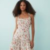 robes longues à pois rouge motif fleuri coton satiné liens buste courte blanche a bretelles nouees et volants portee par un mannequin
