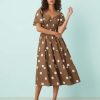 robes longues marron à pois blancs longueur mollet col v volants étagés portée par un mannequin avec des manches courtes et une taille smockée