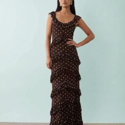 robes longues marron à pois et crème étagés volants en tulle élégante robe marron à pois blancs avec volants et une femme posant trouve en face dun fond bleu clair pour le modèle parfait