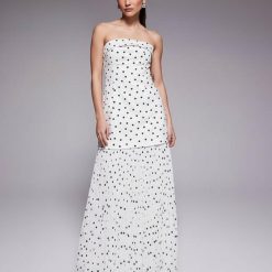 robes à pois transparentes bandeau plissée longue exclusivité petite blanc portée par un mannequin sur fond gris avec des sandales noires