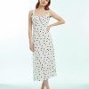 robes roses à pois blanc volants bretelles avec crème imprimé portée par une femme rousse sur un fond clair