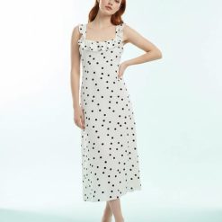 robes roses à pois blanc volants bretelles avec crème imprimé portée par une femme rousse sur un fond clair