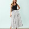 robes roses à pois blanc longue hybride encolure dégagée sans manches élégante femme souriante posant avec une jupe à pois noirs et un haut noir
