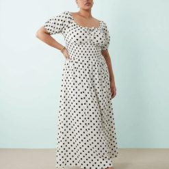 robes à pois blanc et noir bouffantes liens devant plage longue portée par un mannequin avec taille smockée et manches courtes