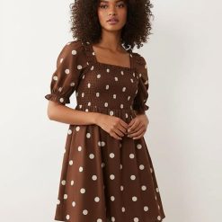robes en tulle à pois courte froncée volanté bord motif marron avec col carré et manches bouffantes portées par une femme sur fond neutre