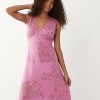 robes à pois filles rose col v longueur mollet imprimé fleuri sans manches portée par une femme aux cheveux bouclés