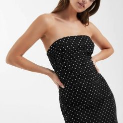 robes longues noires à pois bandeau design moulante sans bretelles portée par un mannequin sur fond clair