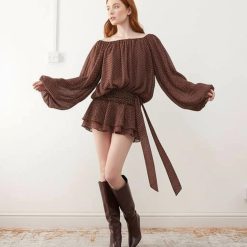 robes manches longues à pois drapée mousseline taille nouée ballon chocolat portée par une femme rousse avec des bottes hautes marron