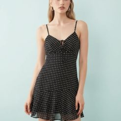 robes à pois chics mousseline courte bretelles en noir une robe élégante avec un motif à petits pois blancs idéale pour lété et les occasions décontractées un vêtement féminin à bretelles fines un style frais et moderne avec de la mousseline et une coupe courte pour un look tendance et confortable pour femme une tenue chic et aérée parfait pour les journées ensoleillées
