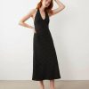 robes à petit pois noir dos nu et blanc longue et élégante portée par une femme aux cheveux roux avec des tongs noires
