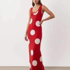robes à pois rouge maille en longue design moulante a grands pois blancs et sans manches portee par un mannequin