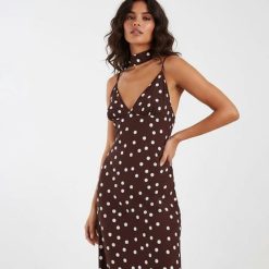 robes évasées à pois longue avec col foulard blanc chocolat portée par une femme à bretelles fines sur fond neutre